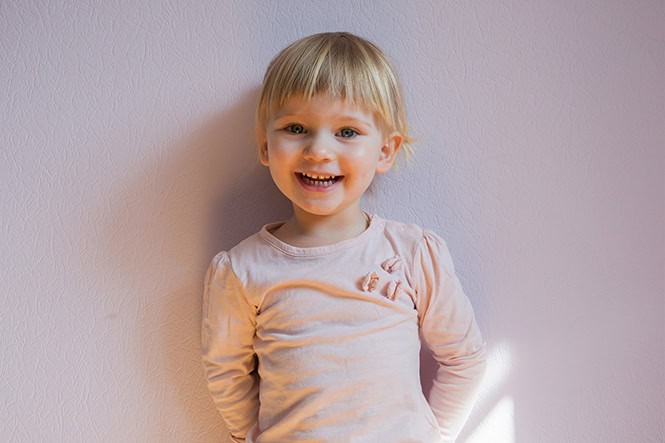 Enfant heureux et souriant, prêt pour la maternelle, portant une chemise rose