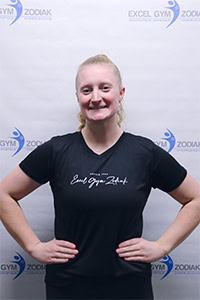 Portrait de Jade L. portant un t-shirt noir, mains sur les hanches.