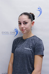 Taïna M. portant un t-shirt gris devant le logo Excel Gym Zone.