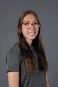 Portrait de Maé-ly P. souriant, portant des lunettes roses.