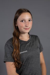 Jeune femme souriante portant un t-shirt gris avec le logo Entraîne