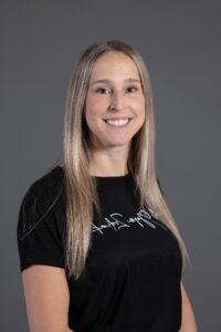 Portrait d'une femme souriante aux cheveux blonds portant un t-shirt noir